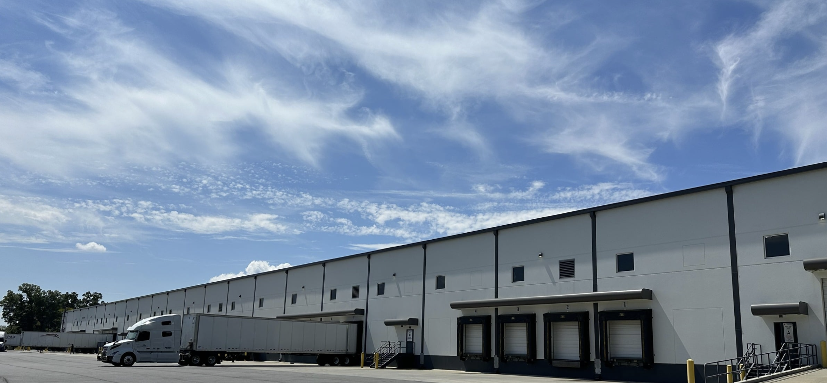 Merchandize Liquidators warehouse exterior with loading docks and trucks